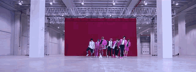 a group of people are standing in front of a red curtain