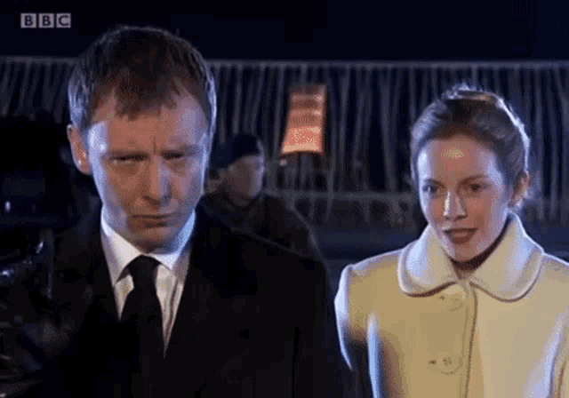 a man and a woman are standing next to each other with bbc written on the bottom