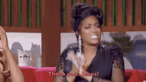 a woman is sitting on a couch with her hands in the air and says thank you jesus