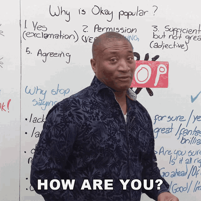 a man stands in front of a white board that says why is okay popular on it