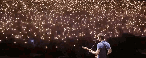 a man singing into a microphone while playing a guitar