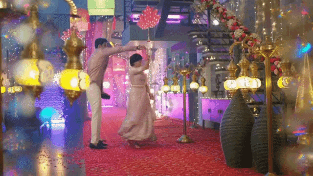 a man and a woman are dancing in a room with lots of lights
