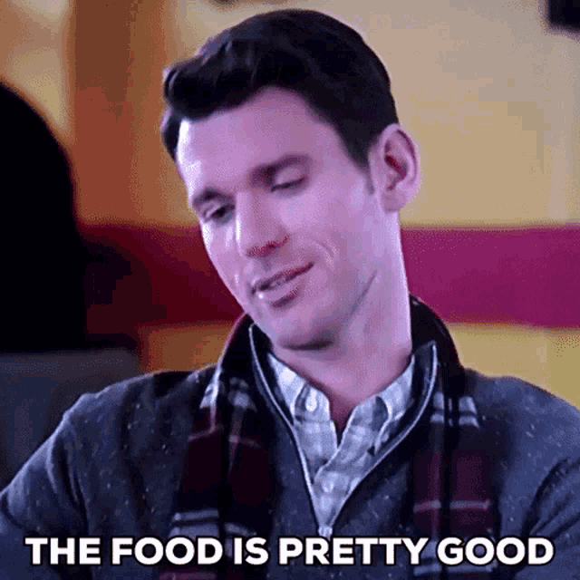 a man with a scarf around his neck is saying the food is pretty good