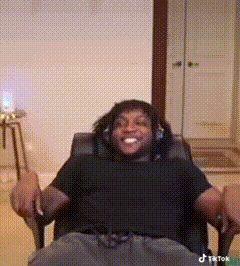 a man wearing headphones is sitting in a chair and smiling