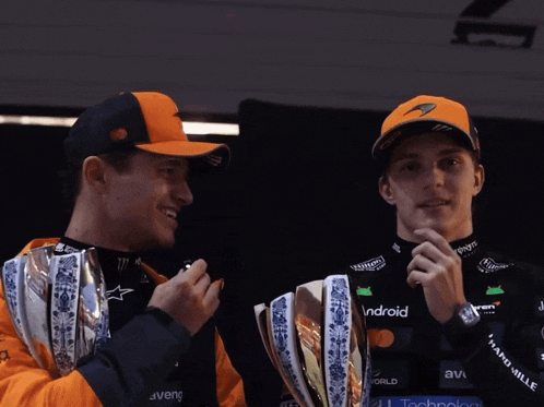 two men holding trophies one of which says droid