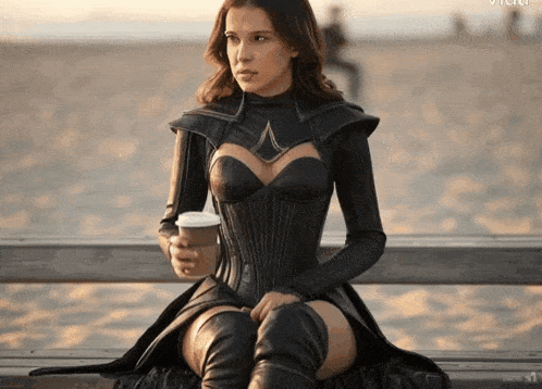 a woman is sitting on a bench with a cup of coffee in her hand