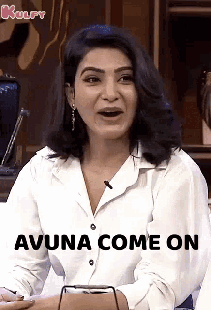 a woman is sitting in front of a microphone and says avuna come on