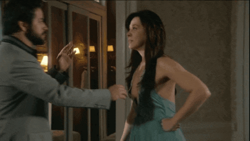 a man in a suit and a woman in a dress are standing next to each other