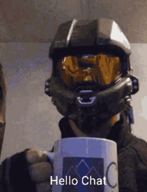 a man wearing a helmet and goggles is holding a coffee mug that says hello chat
