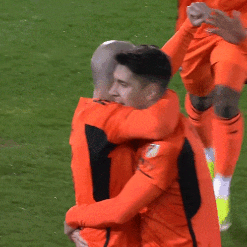 two soccer players are hugging each other on the field