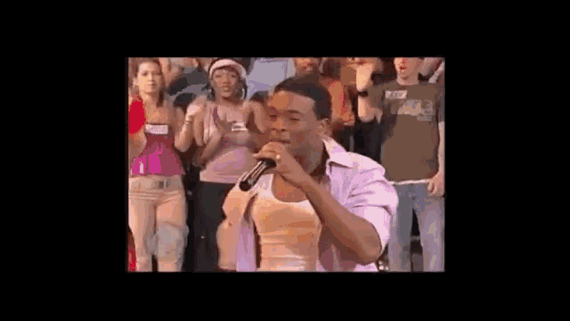 a group of women are dancing in front of a crowd and one of them has a name tag that says phoenix .
