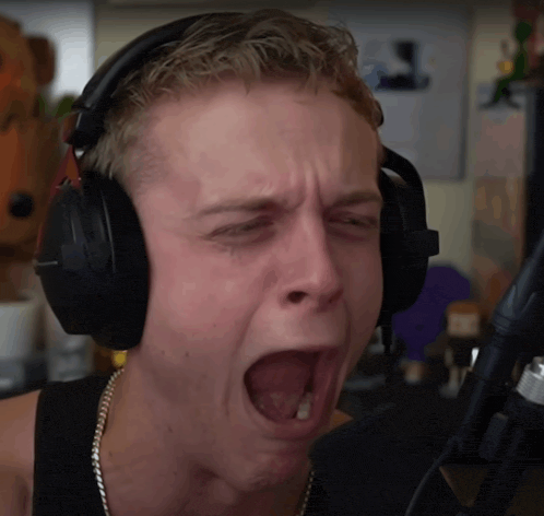 a man wearing headphones making a funny face with his mouth open