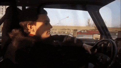 a man in a fur coat is driving a car on a highway