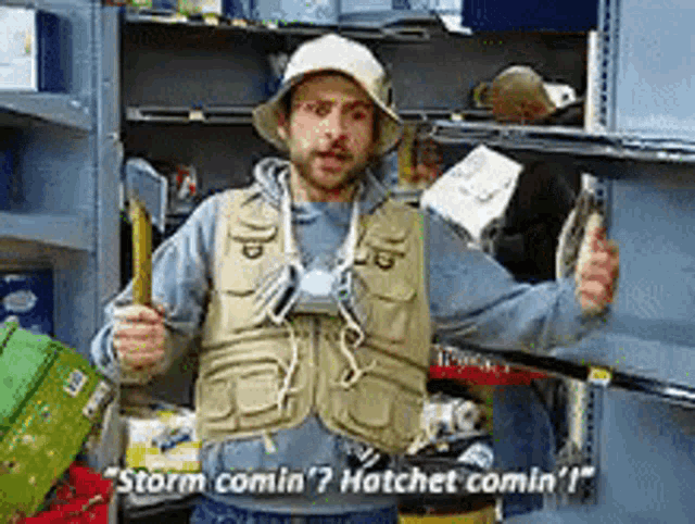 a man in a fishing vest and hat says storm comin