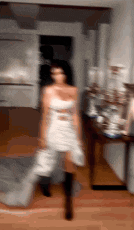 a blurry photo of a woman in a white dress dancing