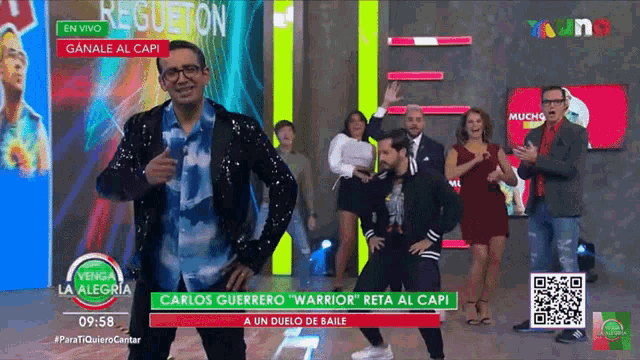 a group of people are dancing in front of a sign that says carlos guerrero warrior reta al capi