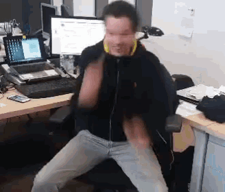 a man is sitting in front of a desk with a laptop and a computer
