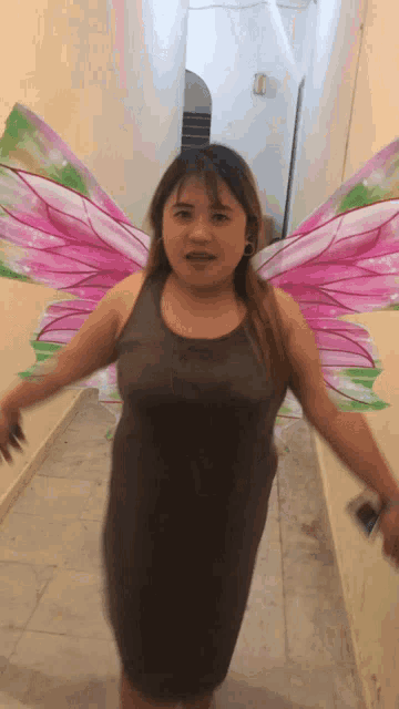 a woman in a dress with pink and green fairy wings
