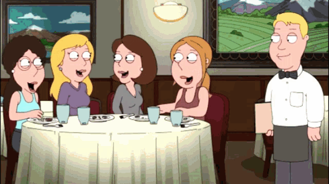 a group of women sit at a table with a waiter
