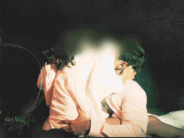 a man and a woman are kissing in front of a sign that says you make magic