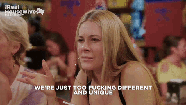 a woman sitting at a table with the words we 're just too fucking different and unique