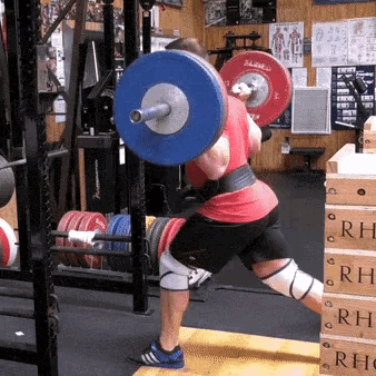 a man squatting with a barbell that says rh on the side