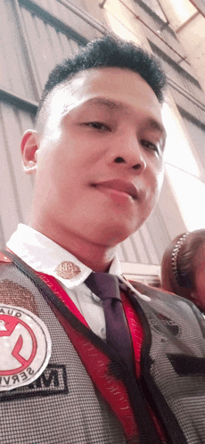 a man wearing a jacket and tie with a badge that says aud