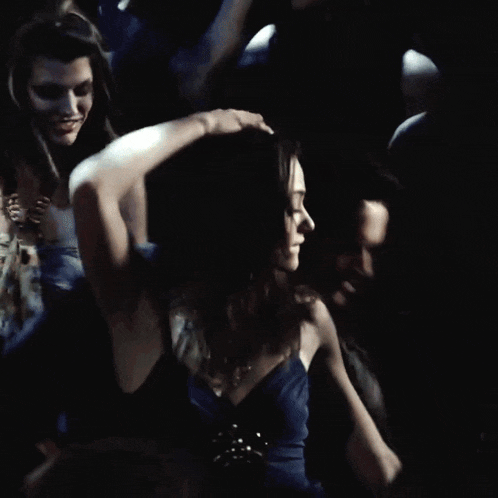 a man holds a woman 's hair in a crowd of people