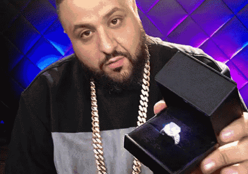 a man with a beard is holding a black box with a diamond in it
