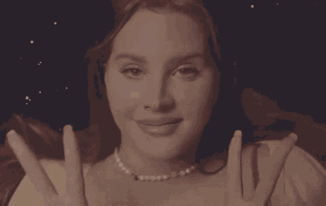 a woman in a yellow sweater and red bra is smiling and looking at the camera .