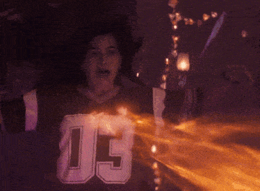 a woman wearing a jersey that says jc is surrounded by flames