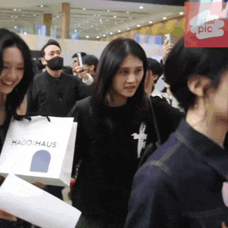 a woman is holding a bag that says hago haus