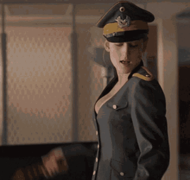 a woman in a military uniform with a hat that has a bird on it