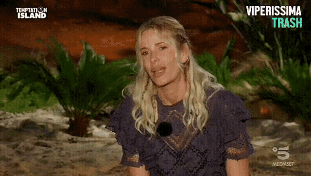 a woman in a purple dress is on a television screen that says " temptation island "