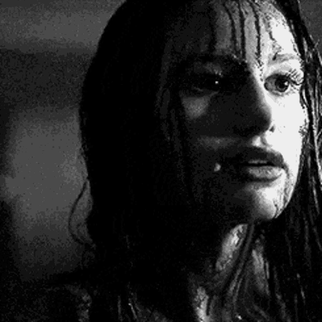 a black and white photo of a woman with blood on her face