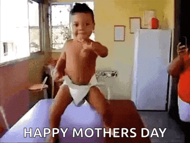 a baby in a diaper is dancing on a table in a room .