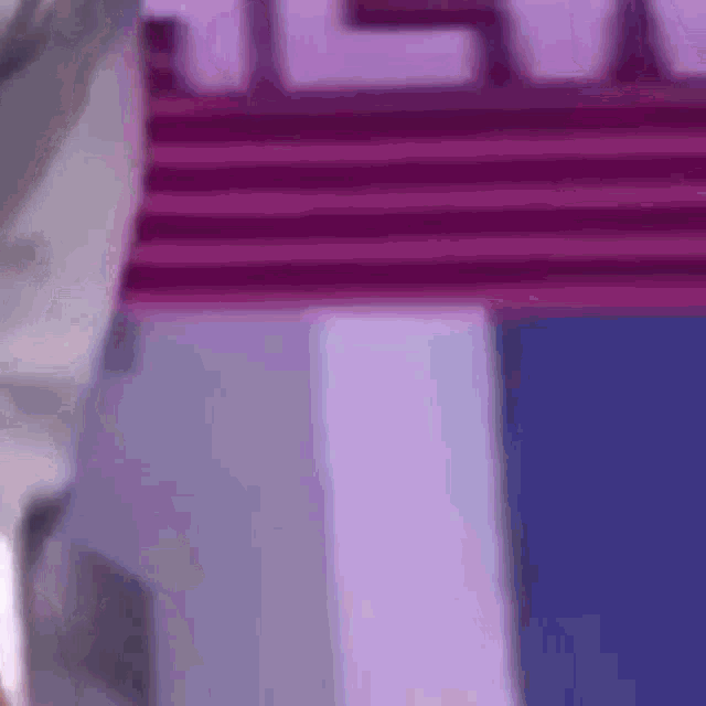 a close up of a purple and white building with a purple roof and stairs .