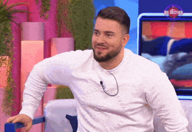 a man with a beard is wearing a white sweater that says big brother on the front