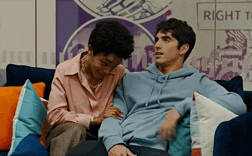 a man and a woman are sitting on a couch in front of a sign that says right