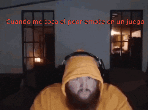 a man with a beard wearing headphones and a yellow hoodie says cuando me toca el peor emote