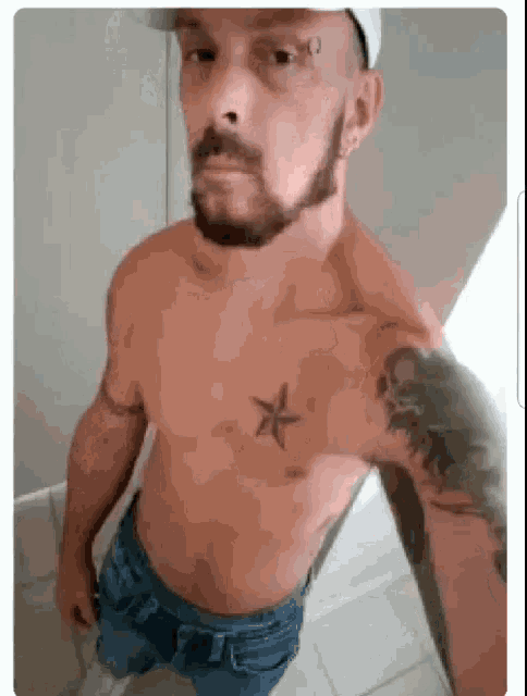 a shirtless man with a beard is taking a selfie in a bathroom .