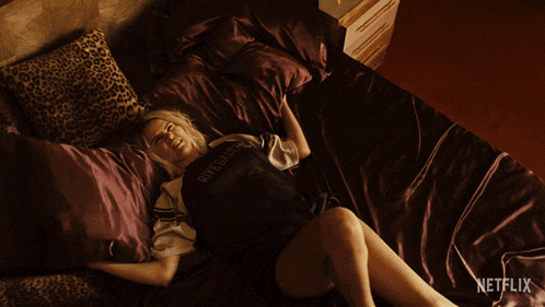 a woman laying on a bed with a netflix logo in the corner
