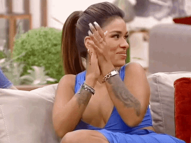 a woman sitting on a couch with her hands on her face