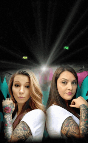 two women are standing back to back with their arms crossed