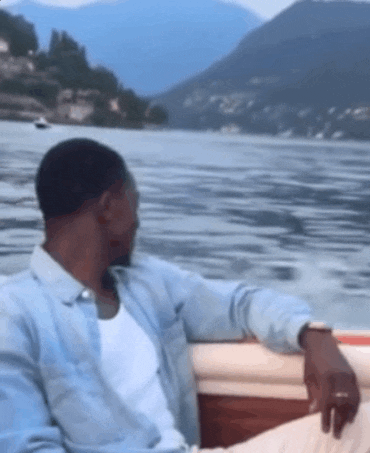 a man is sitting on a boat looking at the water
