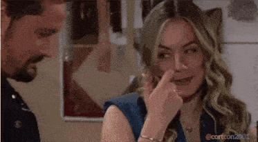 a woman is making a face while a man looks on .