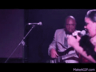 a man playing a guitar and a woman singing into a microphone
