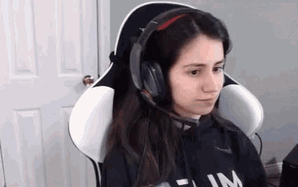 a woman wearing headphones and a microphone is sitting in a gaming chair .