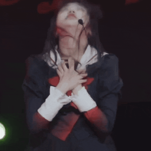 a girl in a school uniform is making a cross with her hands