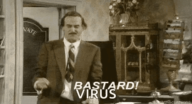 a man in a suit and tie is standing in a room and saying `` bastard ! virus '' .